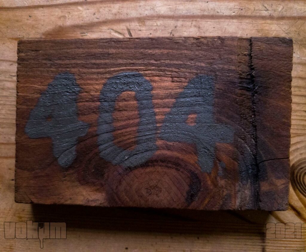 Piece of wood (plank) with '404' written on it with some industrial black/grey paint