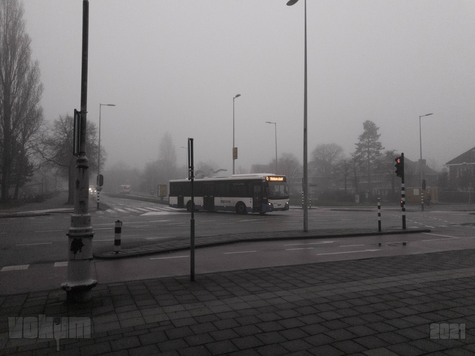 Misty Amsterdam (zuid). Crossing Apollolaan and Stadionweg. A public transport bus takes a turn.