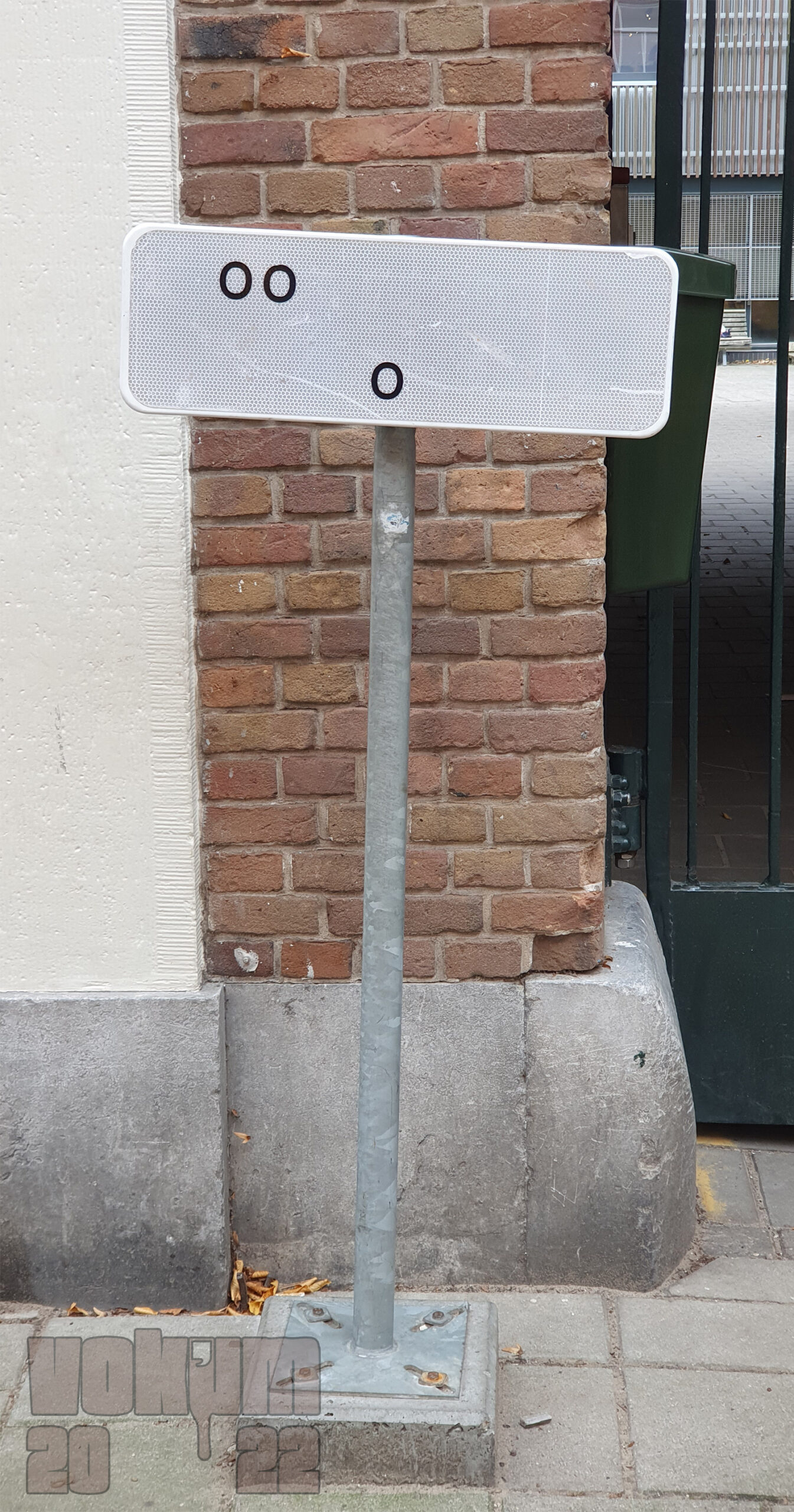 Traffic sign in front of an entrance with only a doubble o and a single o left.